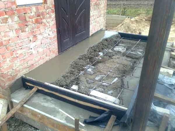 Уложите арматуру на первый слой бетона и залейте раствор